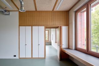 Blick aus Gruppenraum in Klassenzimmer Trakte B und C. Linoleumboden, Akustikdecke und Einbauten aus Holz (© Roland Bernath, Zürich)